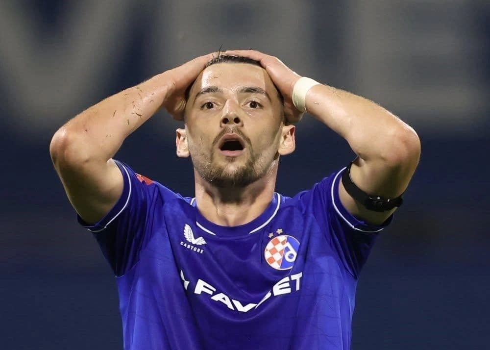 Futbollist me fanellën blu të Dinamos së Zagrebit, me duart mbi kokë.