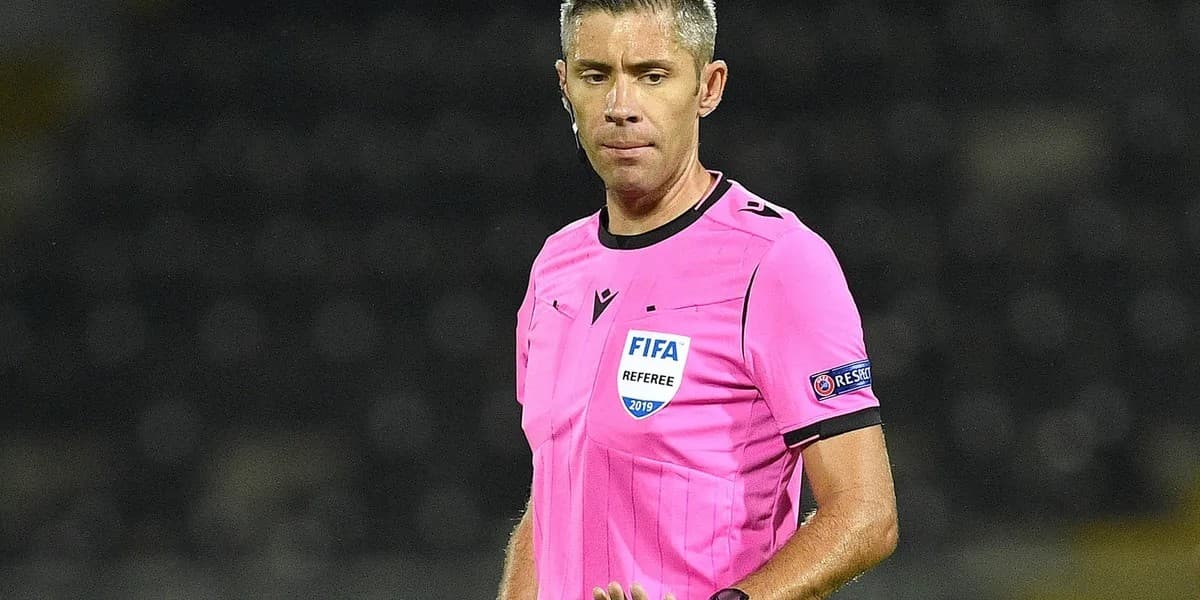 Radu Petrescu me uniformë rozë gjyqtari dhe mikrofon në një ambient stadiumi.