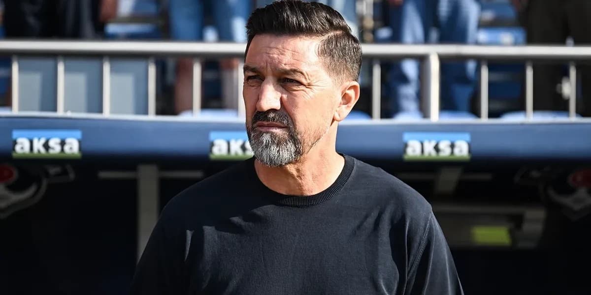 Besnik Hasi me bluzë të zezë pranë stolit të stadiumit.